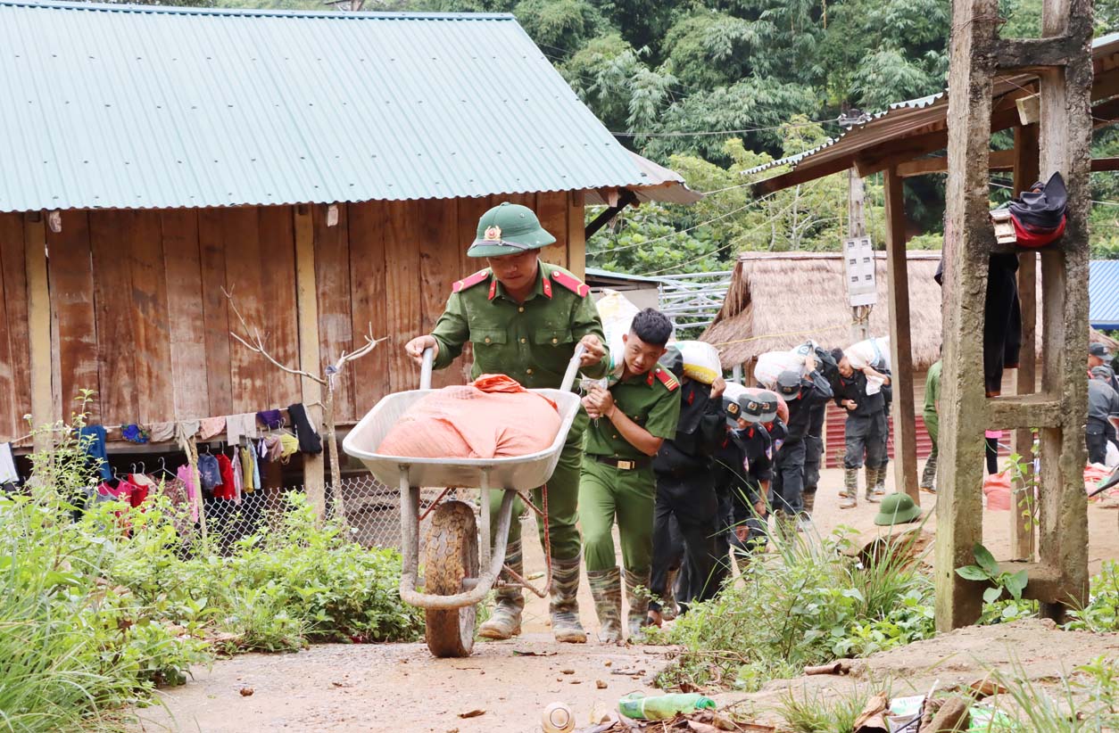 Cán bộ, chiến sỹ Phòng Cảnh sát cơ động vận chuyển vật liệu để xây nhà cho dân bản Huổi Han (xã Bum Tở, huyện Mường Tè).	
